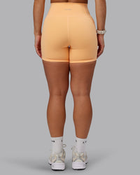 Woman wearing Fusion Ultra High-Rise 6" Short Pockets - Peach Fuzz | Model:Lyss | Size:S
