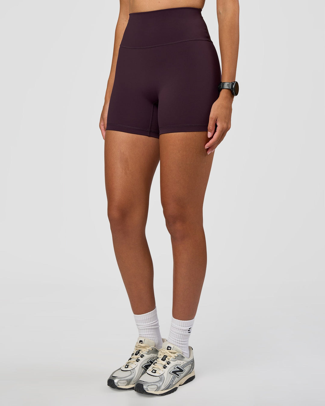 Woman wearing Fusion Ultra High-Rise 4" Short - Midnight Plum | Set:true | Angle:side | Model:Rhiley | Size:S