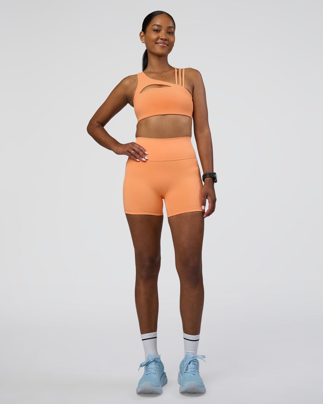 Woman wearing Fusion Ultra High-Rise 4&quot; Short Pockets - Cantaloupe | Model:Rica | Size:S