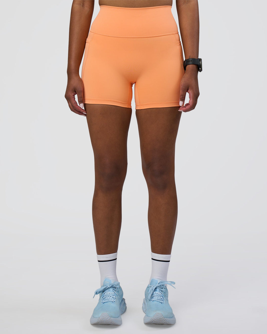 Woman wearing Fusion Ultra High-Rise 4&quot; Short Pockets - Cantaloupe | Model:Rica | Size:S