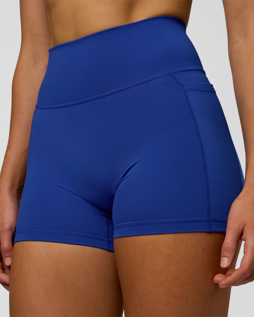 Woman wearing Fusion Ultra High-Rise 4" Short Pockets - Electric Indigo | Model:Evie | Size:S