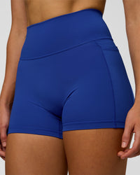 Woman wearing Fusion Ultra High-Rise 4" Short Pockets - Electric Indigo | Model:Evie | Size:S