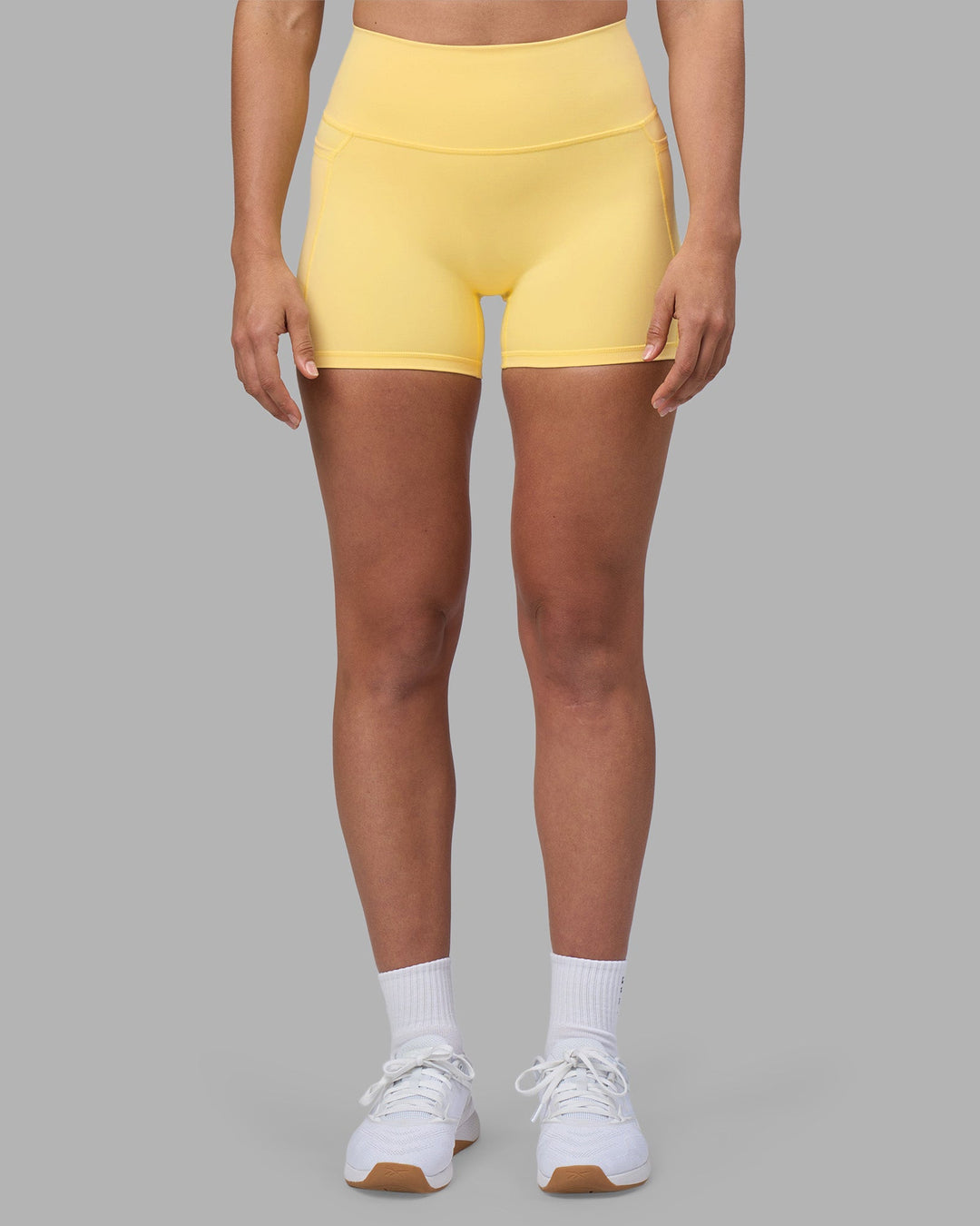 Woman wearing Fusion Ultra High-Rise 4" Short Pockets - Lemon | Model:Sophie | Size:S