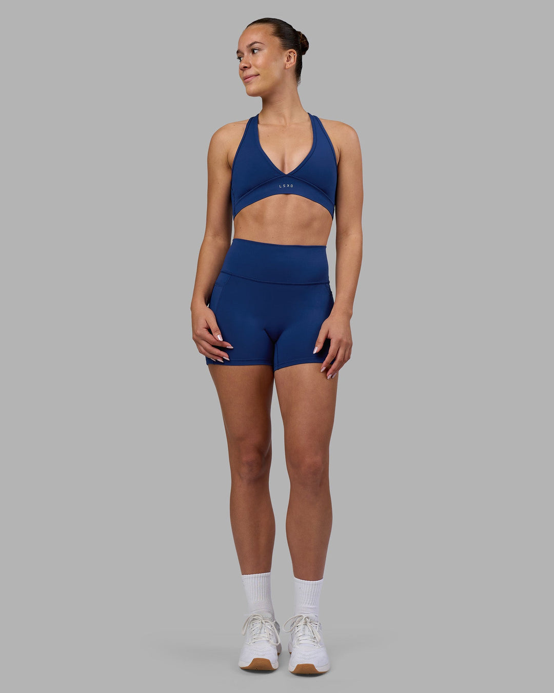 Woman wearing Fusion Ultra High-Rise 4" Short Pockets - Midnight Blue | Model:Charlize | Size:S
