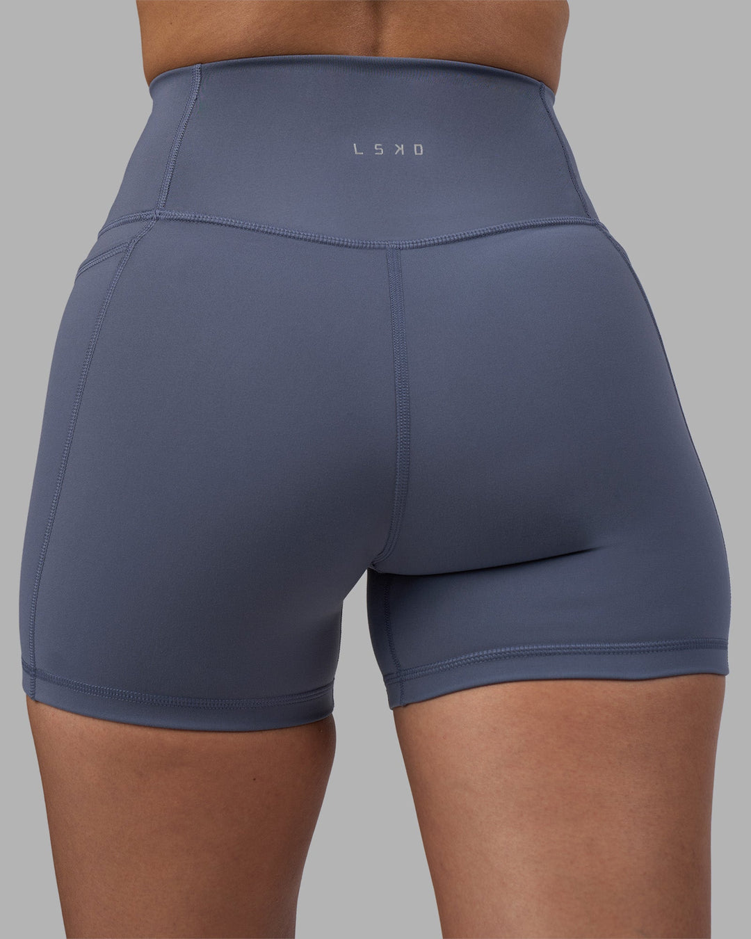 Woman wearing Fusion Ultra High-Rise 4&quot; Short Pockets - Night Shadow | Model:Rhiley | Size:S