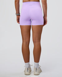 Woman wearing Fusion Ultra High-Rise 4" Short Pockets - Pale Lilac | Set:true | Angle:back | Model:Emelia | Size:S