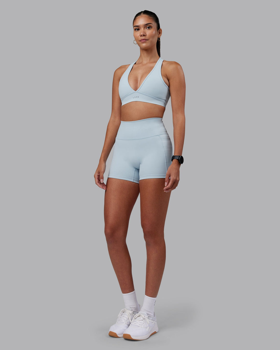 Woman wearing Fusion Ultra High-Rise 4&quot; Short Pockets - Skyride | Model:Rhiley | Size:S