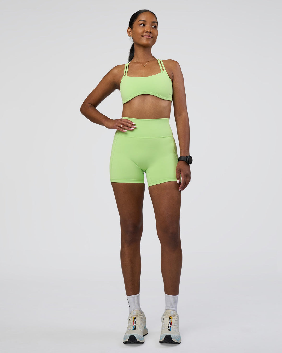 Woman wearing Fusion Ultra High-Rise 4&quot; Short Pockets - Solar Lime | Model:Rica | Size:S