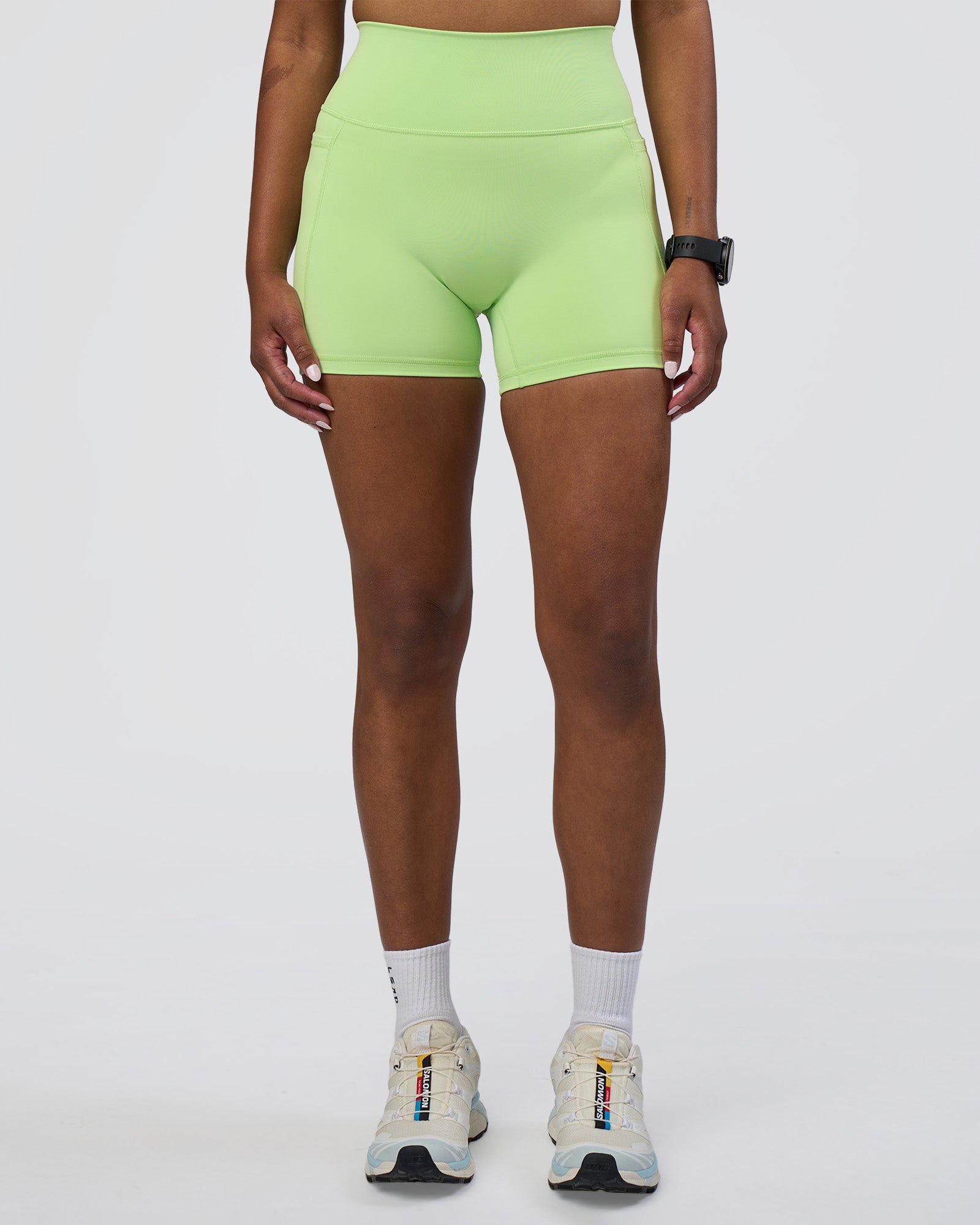 Woman wearing Fusion Ultra High-Rise 4" Short Pockets - Solar Lime | Model:Rica | Size:S