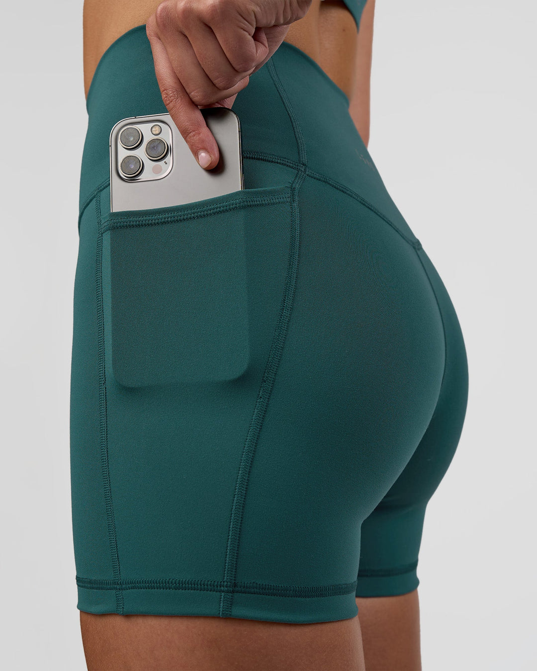 Woman wearing Fusion Ultra High-Rise 4" Short Pockets - Transformative Teal | Model:Myrte | Size:S