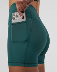 Woman wearing Fusion Ultra High-Rise 4" Short Pockets - Transformative Teal | Model:Myrte | Size:S