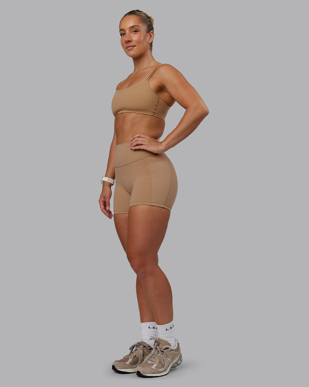 Woman wearing Fusion Ultra High-Rise 4&quot; Short Pockets - Warm Smoke | Model:Lyss | Size:S