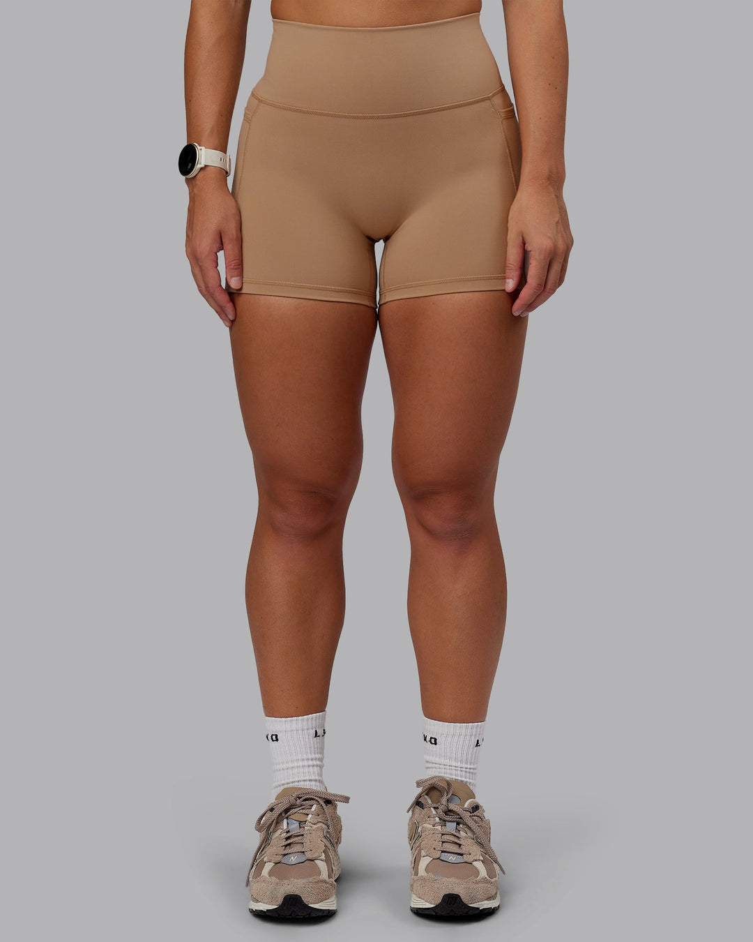 Woman wearing Fusion Ultra High-Rise 4&quot; Short Pockets - Warm Smoke | Model:Lyss | Size:S