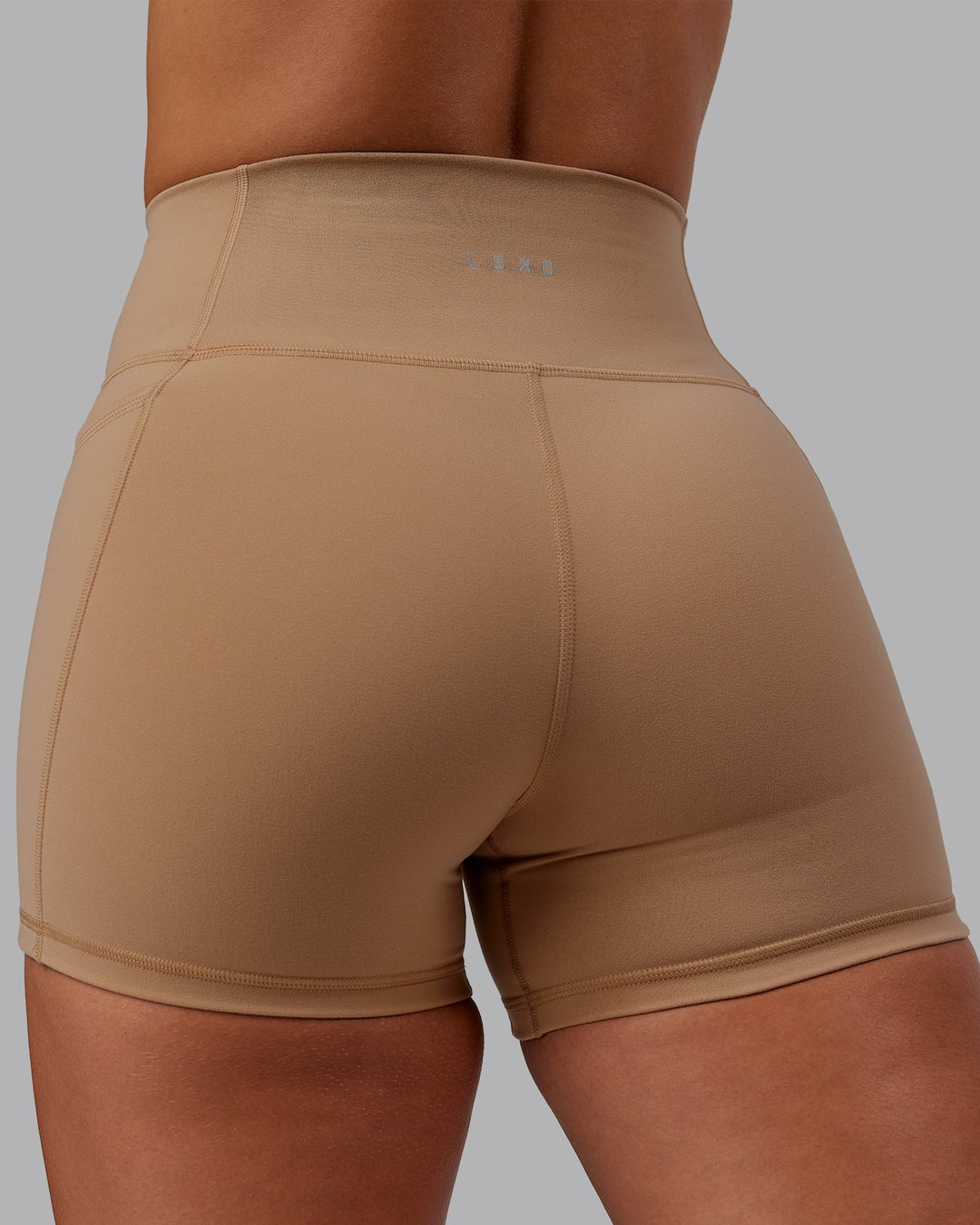 Woman wearing Fusion Ultra High-Rise 4&quot; Short Pockets - Warm Smoke | Model:Lyss | Size:S