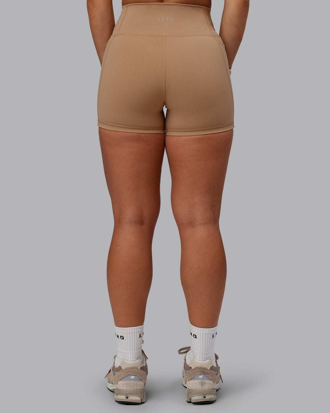 Woman wearing Fusion Ultra High-Rise 4&quot; Short Pockets - Warm Smoke | Model:Lyss | Size:S