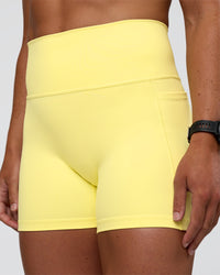 Woman wearing Fusion Ultra High-Rise 4" Short Pockets - Yellow Fizz | Model:Sav | Size:S