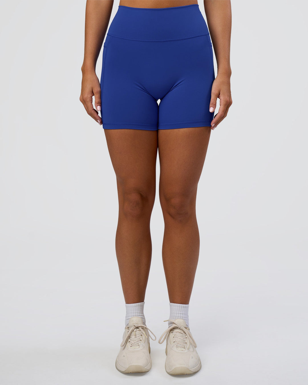 Woman wearing Fusion Ultra High-Rise 6" Short Pockets - Electric Indigo | Set:true | Angle:front | Model:Amity | Size:S