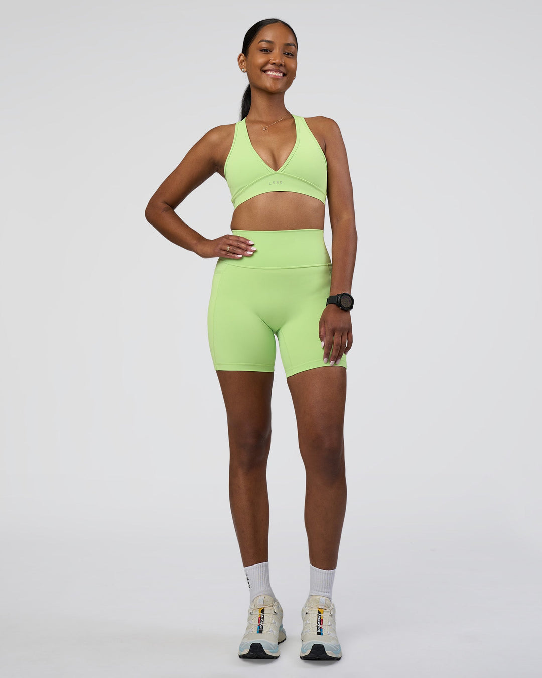 Woman wearing Fusion Ultra High-Rise 6&quot; Short Pockets - Solar Lime | Model:Rica | Size:S