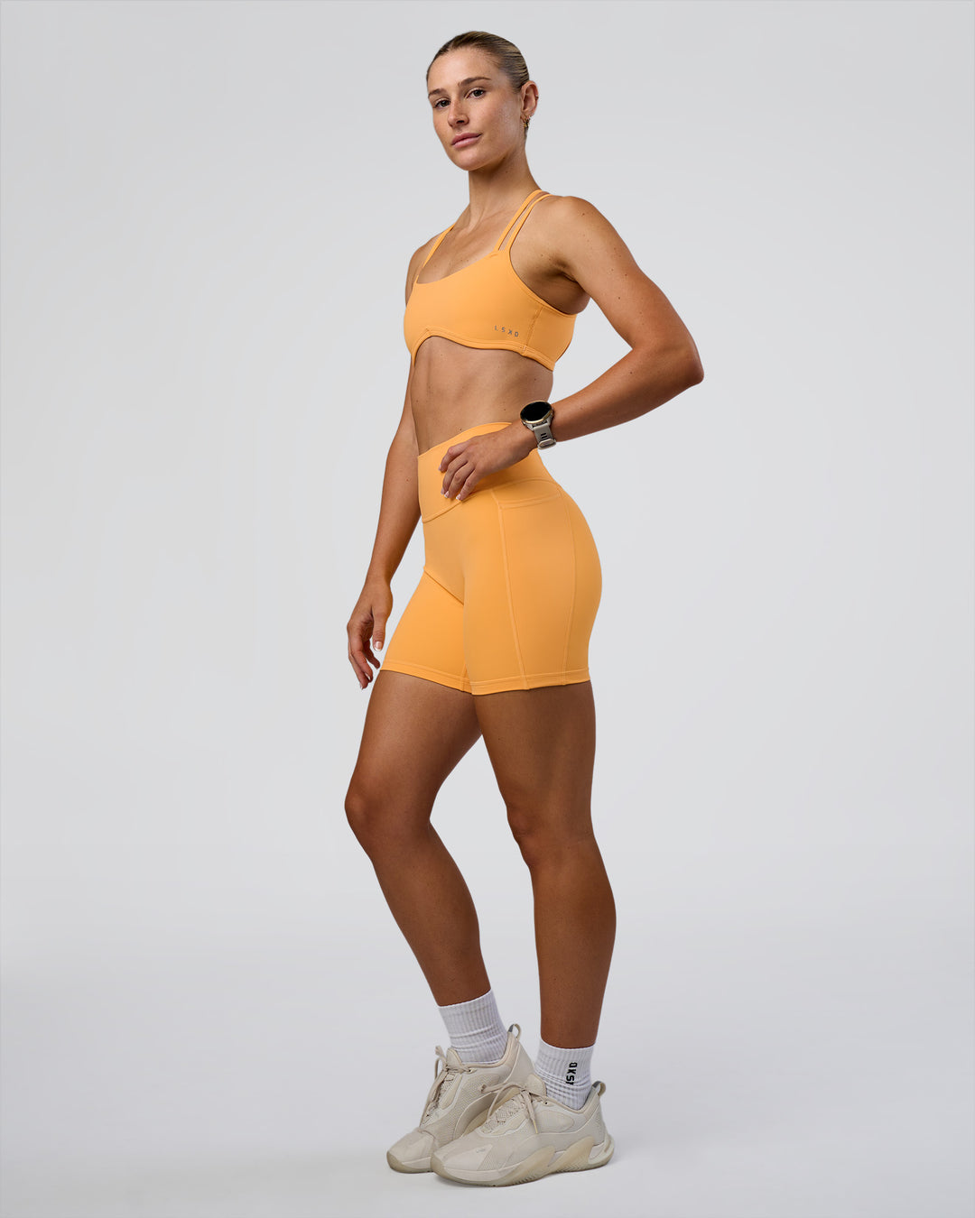 Woman wearing Fusion Ultra High-Rise 6&quot; Short Pockets - Warm Apricot | Model:Emelia | Size:S