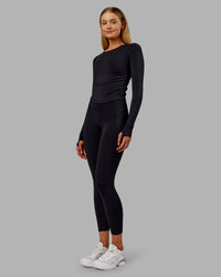 Woman wearing Fusion Ultra High-Rise 7/8 Thermal Legging Pockets - Black | Model:Ella | Size:S