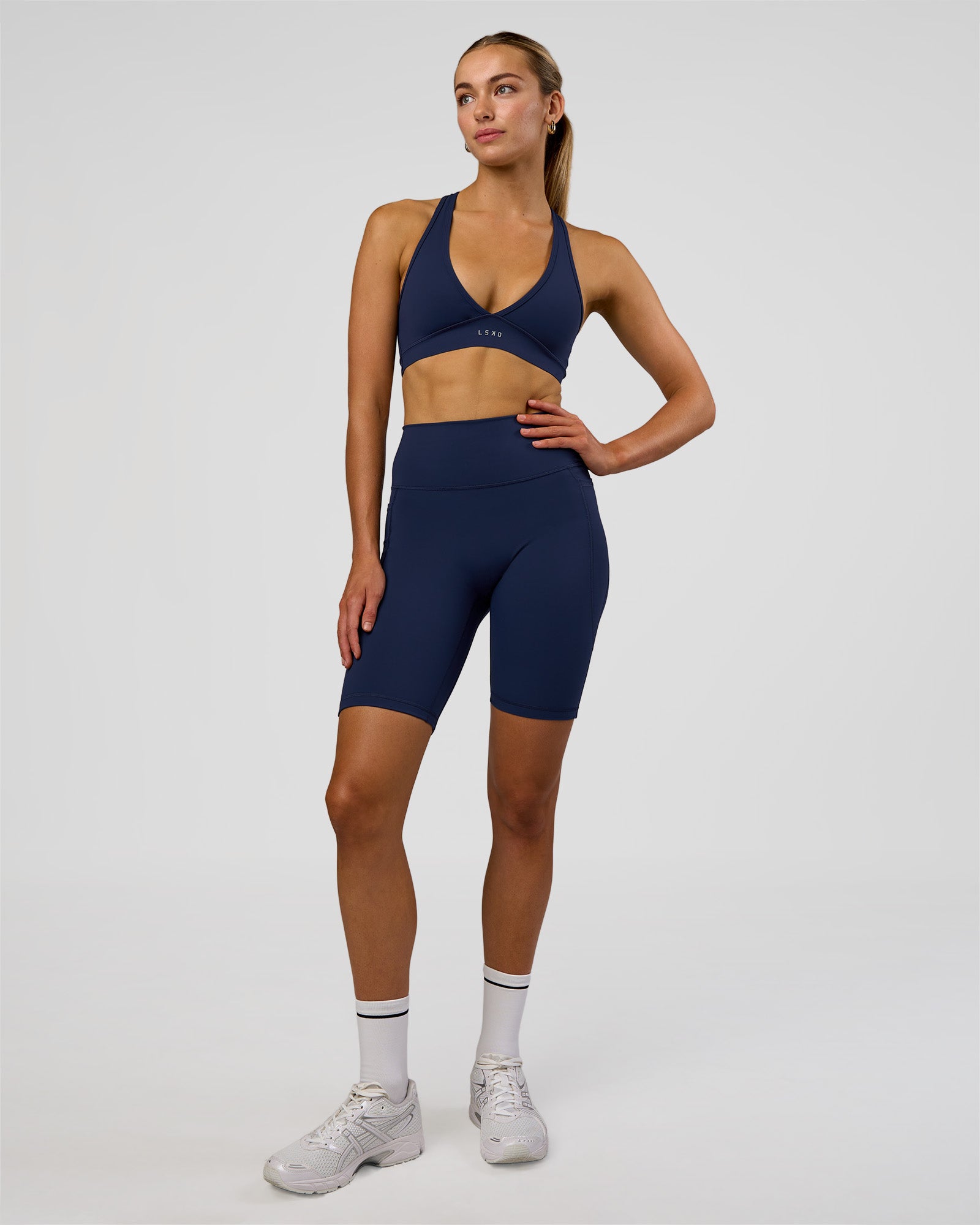 Woman wearing Fusion Ultra High-Rise 9" Short Pockets - Future Navy | Model:Evie | Size:S