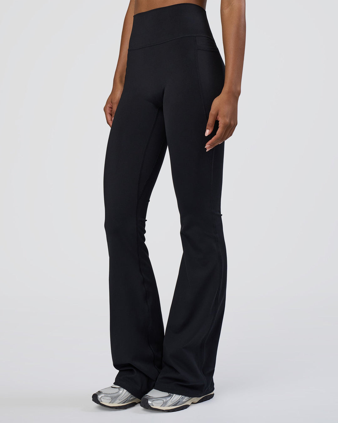 Woman wearing Fusion Ultra High-Rise Flared Tall Legging Pockets - Black | Model:Tomi | Size:S