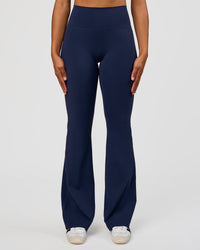 Woman wearing Fusion V-Contour High-Rise Flared Tall Legging Pockets - Future Navy | Model:Rosie | Size:S