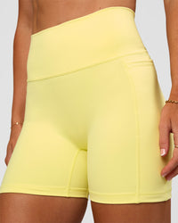 Woman wearing Fusion V-Contour Ultra High-Rise 4” Short Pockets - Yellow Fizz | Model:Emelia | Size:S