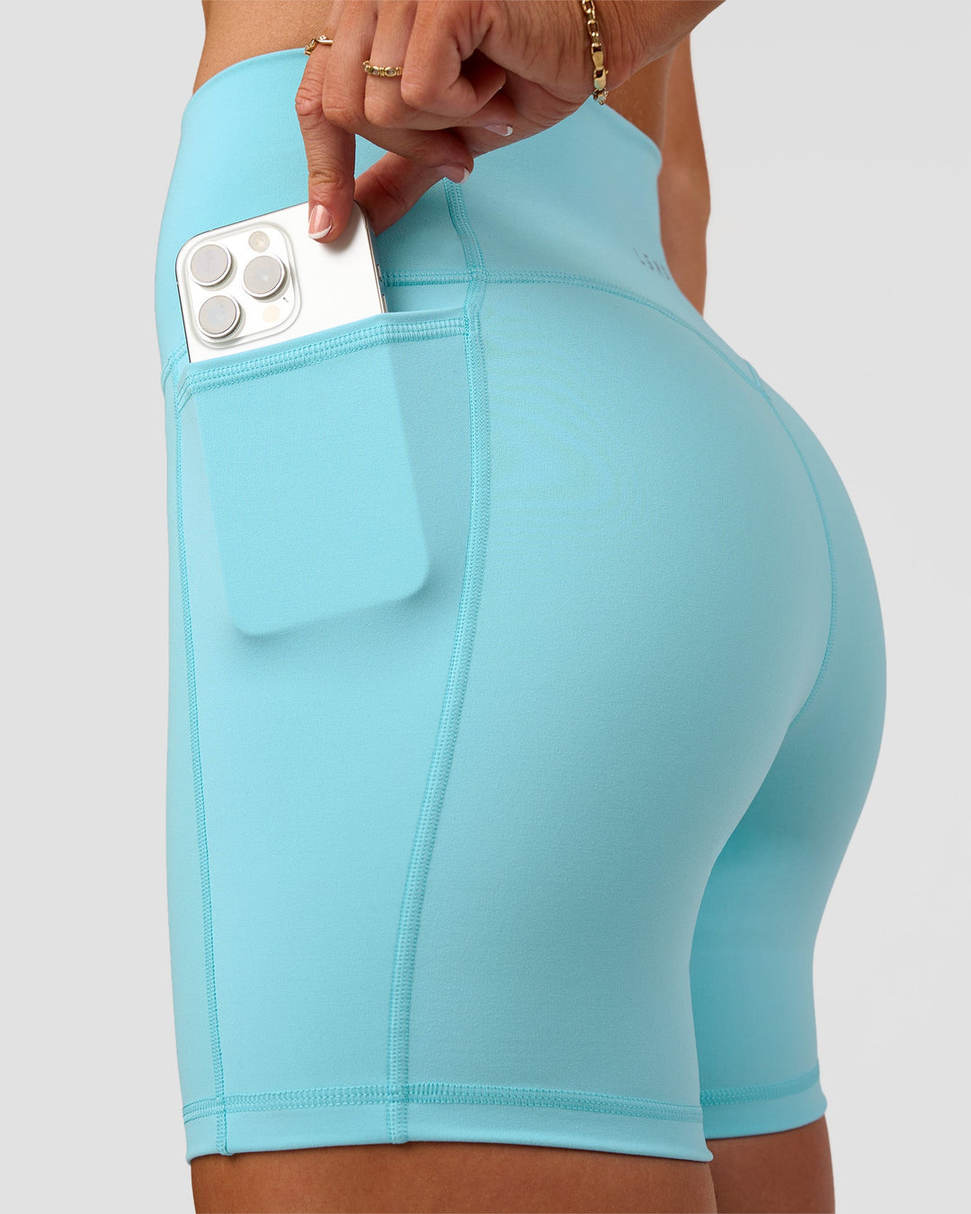 Woman wearing Fusion V-Contour Ultra High-Rise 6" Short Pockets - Baltic Sea | Model:Emelia | Size:S
