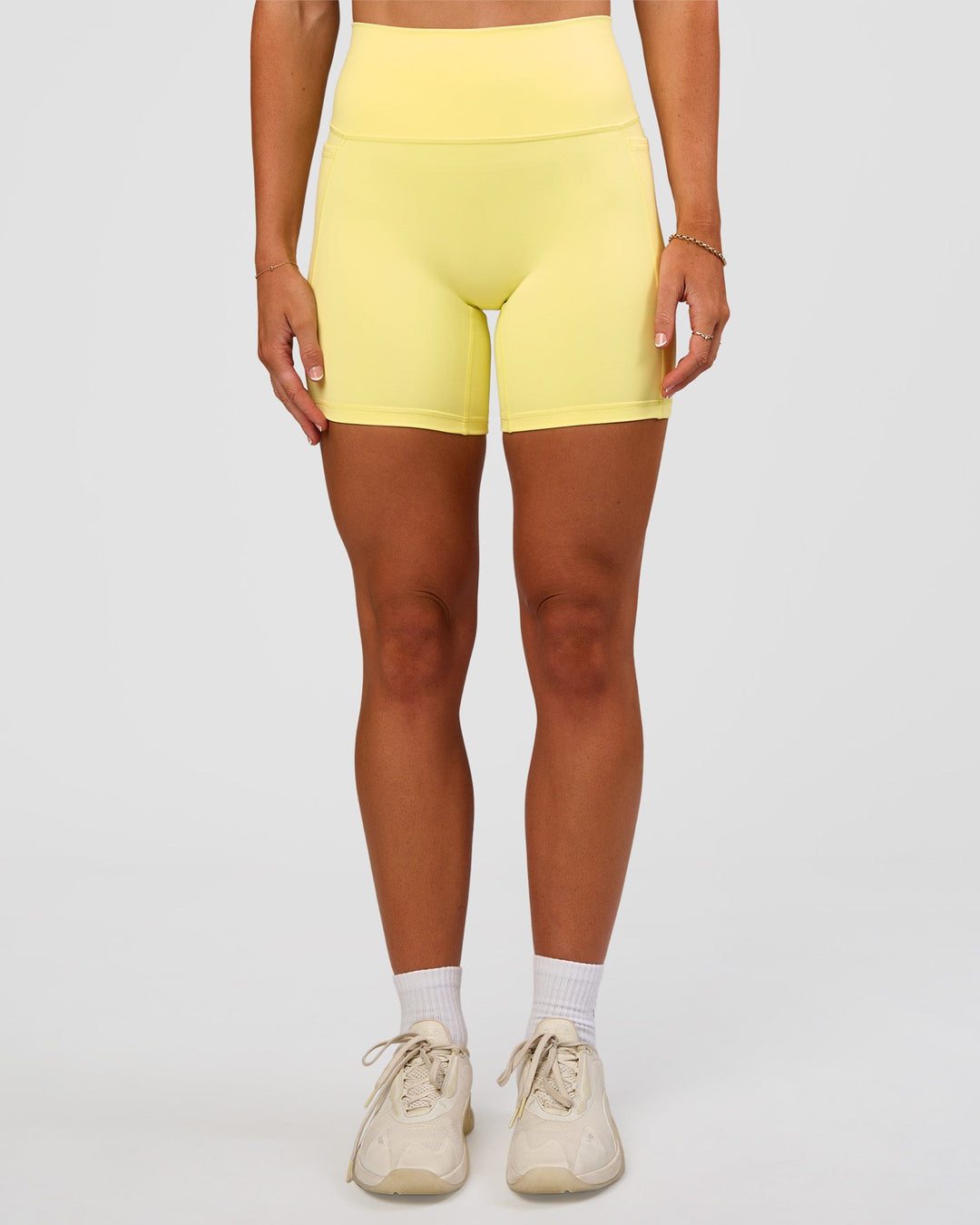 Woman wearing Fusion V-Contour Ultra High-Rise 6" Short Pockets - Yellow Fizz | Model:Emelia | Size:S