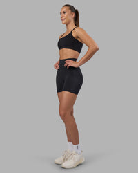 Woman wearing Fusion V-Contour Ultra High-Rise 4” Short Pockets - Black | Model:Charlize | Size:S