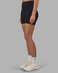 Woman wearing Fusion V-Contour Ultra High-Rise 4” Short Pockets - Black | Model:Charlize | Size:S