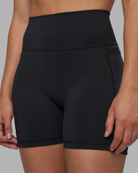 Woman wearing Fusion V-Contour Ultra High-Rise 4” Short Pockets - Black | Model:Charlize | Size:S