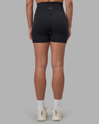 Woman wearing Fusion V-Contour Ultra High-Rise 4” Short Pockets - Black | Model:Charlize | Size:S