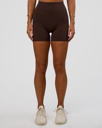 Woman wearing Fusion V-Contour Ultra High-Rise 4” Short Pockets - Hot Chocolate | Model:Amity | Size:S
