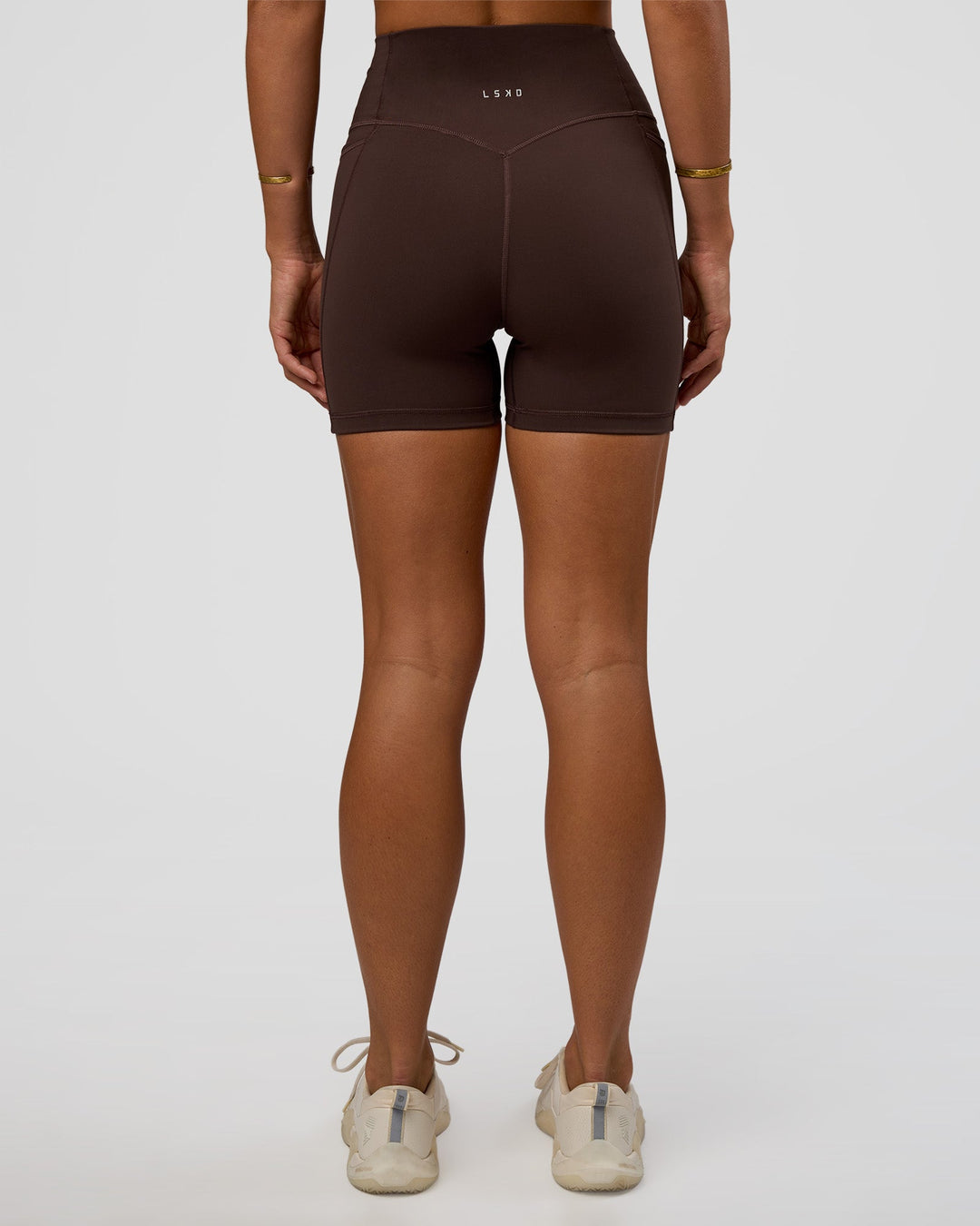 Woman wearing Fusion V-Contour Ultra High-Rise 4” Short Pockets - Hot Chocolate | Model:Amity | Size:S