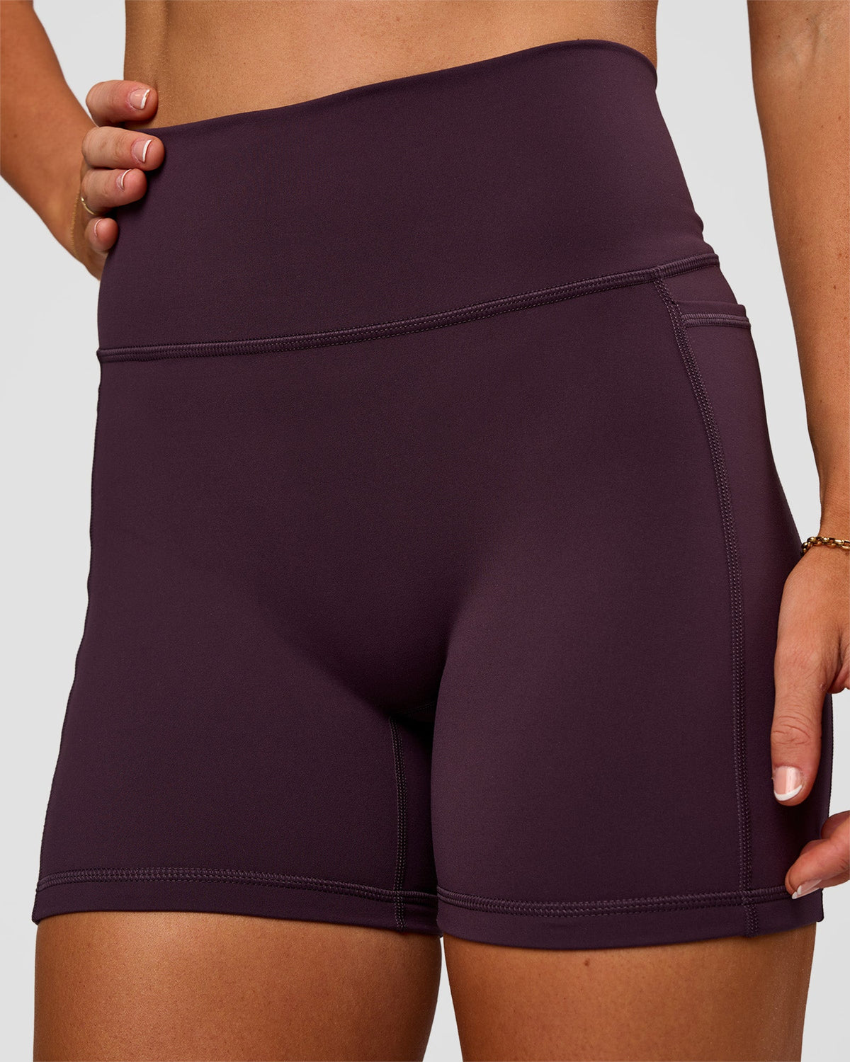 Woman wearing Fusion V-Contour Ultra High-Rise 4” Short Pockets - Midnight Plum | Model:Emelia | Size:S - view 2