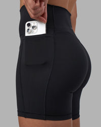 Woman wearing Fusion V-Contour Ultra High-Rise 6" Short Pockets - Black | Model:Charlize | Size:S
