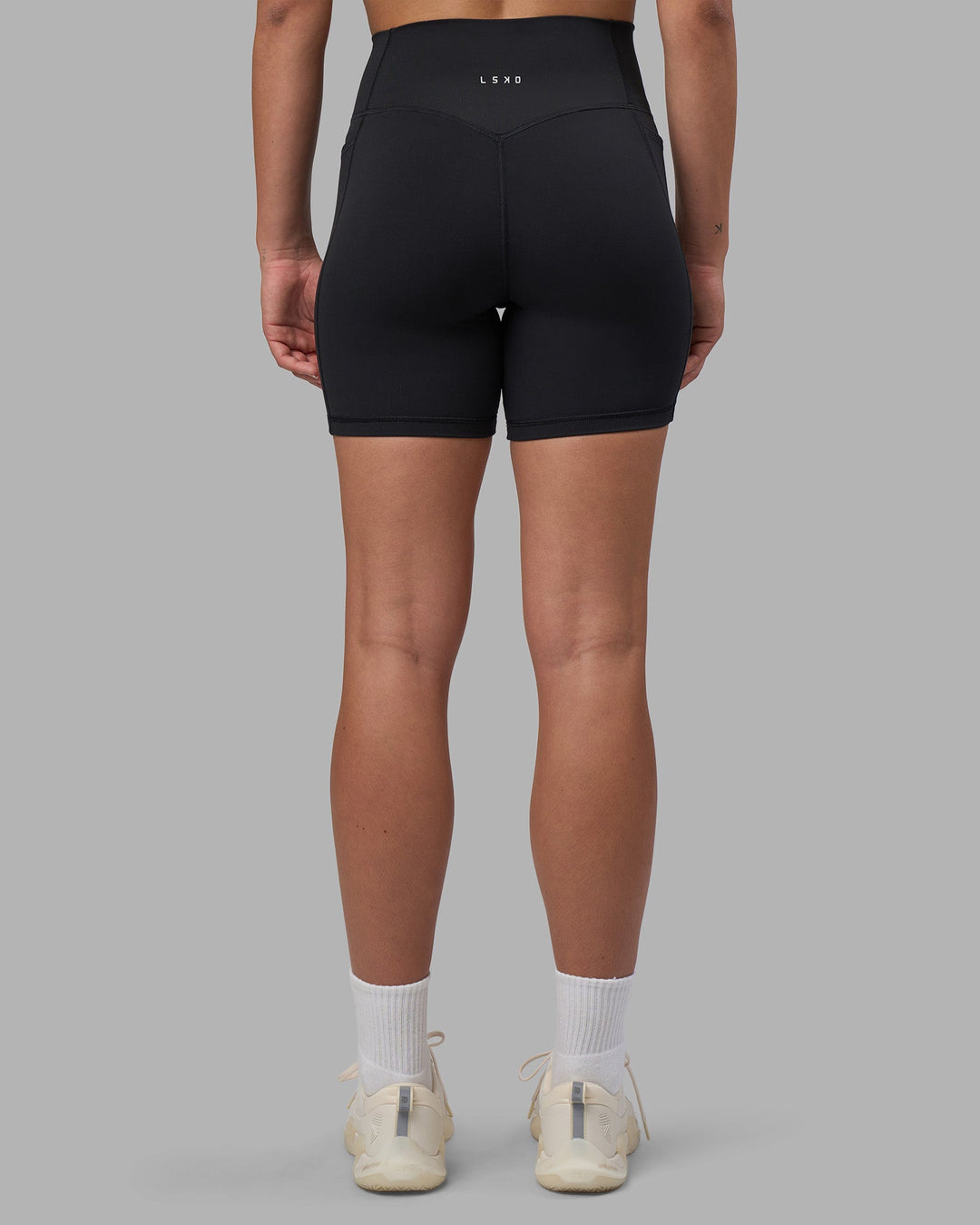 Woman wearing Fusion V-Contour Ultra High-Rise 6&quot; Short Pockets - Black | Model:Charlize | Size:S