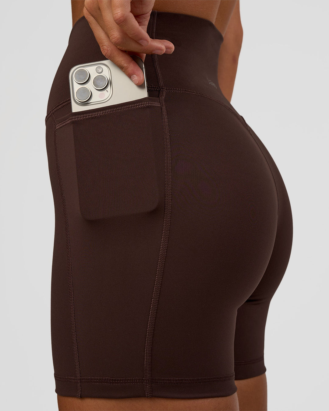 Woman wearing Fusion V-Contour Ultra High-Rise 6&quot; Short Pockets - Hot Chocolate | Model:Amity | Size:S