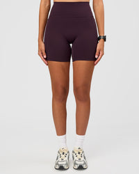 Woman wearing Fusion V-Contour Ultra High-Rise 6" Short Pockets - Midnight Plum | Model:Rhiley | Size:S