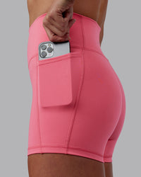 Woman wearing Fusion Ultra High-Rise 4" Short Pockets - Pink Lemonade | Set:true | Angle:closeup | Model:Shae | Size:S