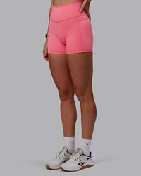 Woman wearing Fusion Ultra High-Rise 4" Short Pockets - Pink Lemonade | Set:true | Angle:side | Model:Shae | Size:S