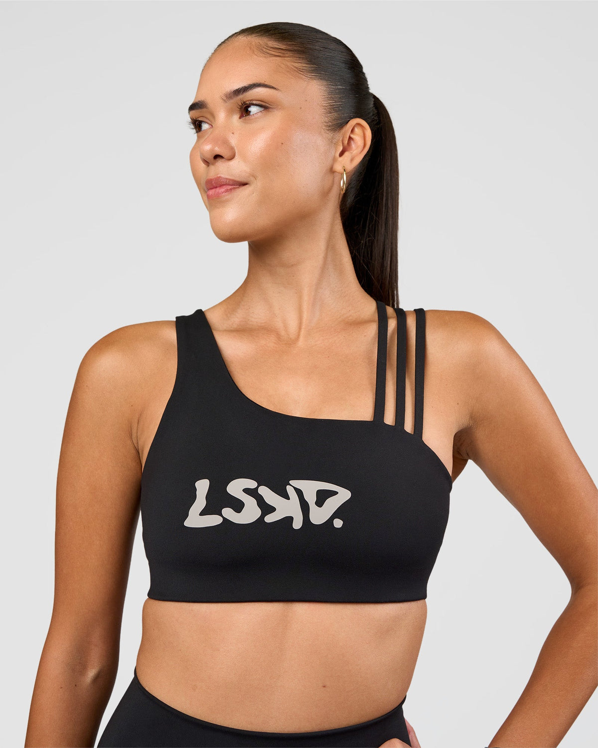 Woman wearing Galvanise Hype Graphic Sports Bra 2.0 - Black-Alloy | Model:Rhiley | Size:S - view 1