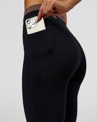 Woman wearing Liberate High-Rise Full Length Legging Pockets in Black-Cocoa Powder | Model:Bianca | Size:S | Thumbnail Index: 1