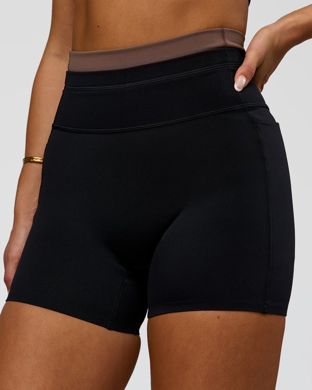 Woman wearing Liberate High-Rise 4" Short Pockets in Black-Cocoa Powder | Model:Bianca | Size:S - view 1