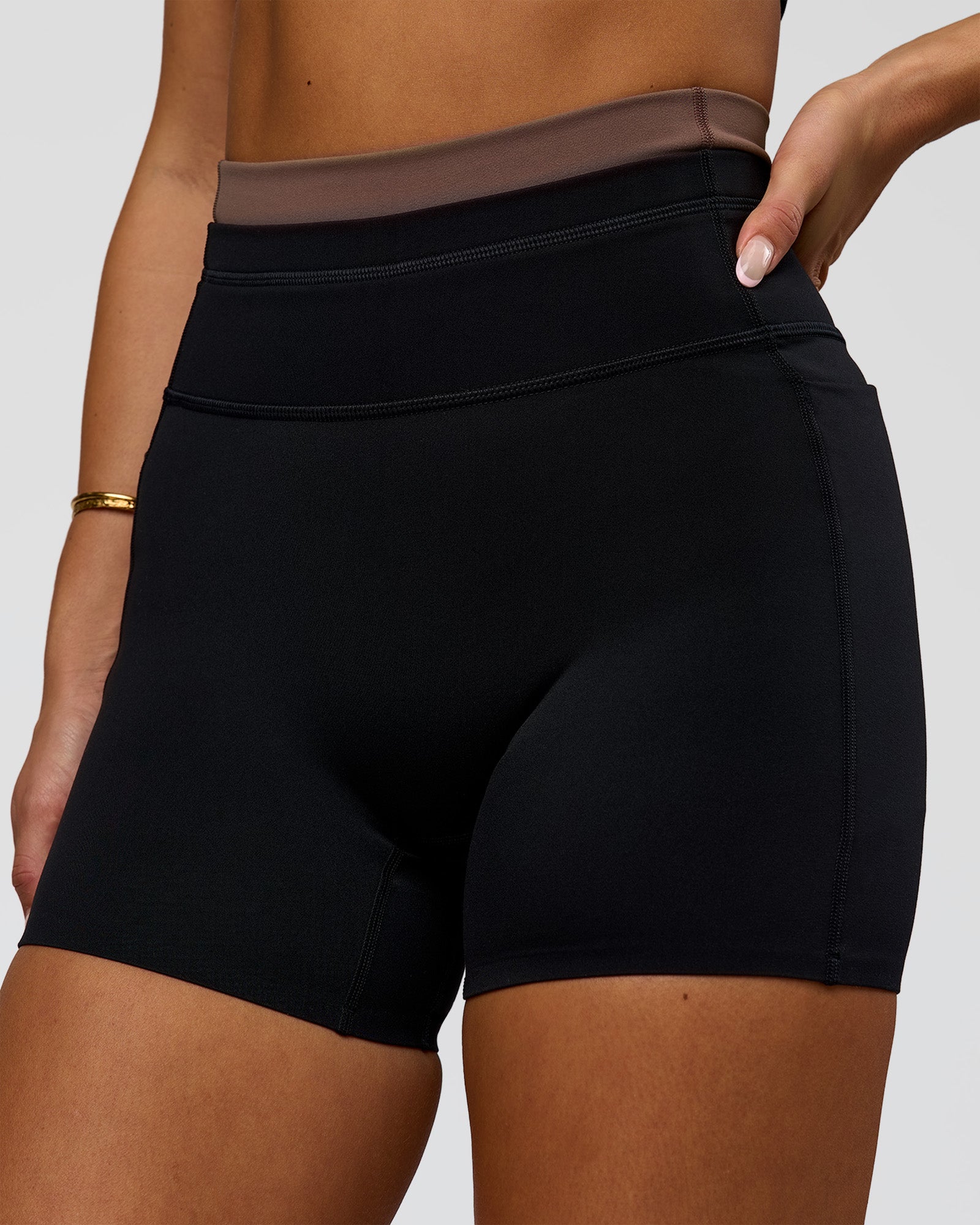 Woman wearing Liberate High-Rise 4" Short Pockets in Black-Cocoa Powder | Model:Bianca | Size:S