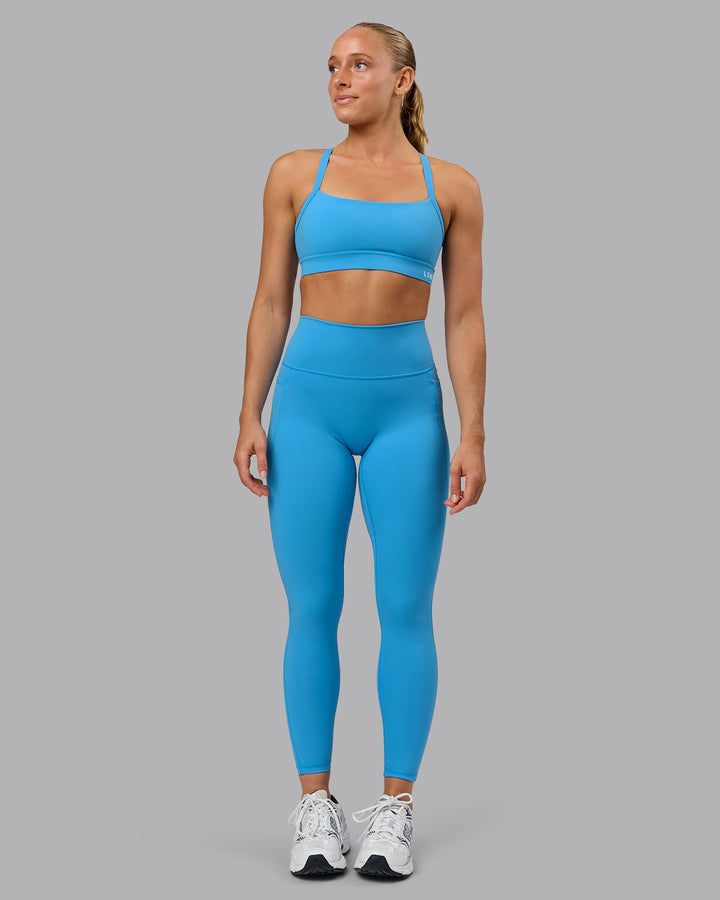 Woman wearing Momentum Sports Bra in Azure Blue | Size:S
