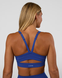 Woman wearing Momentum Sports Bra - Electric Indigo | Model:Amity | Size:S