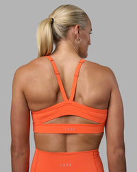 Woman wearing Momentum Sports Bra - Ultra Orange | Model:Katie | Size:S